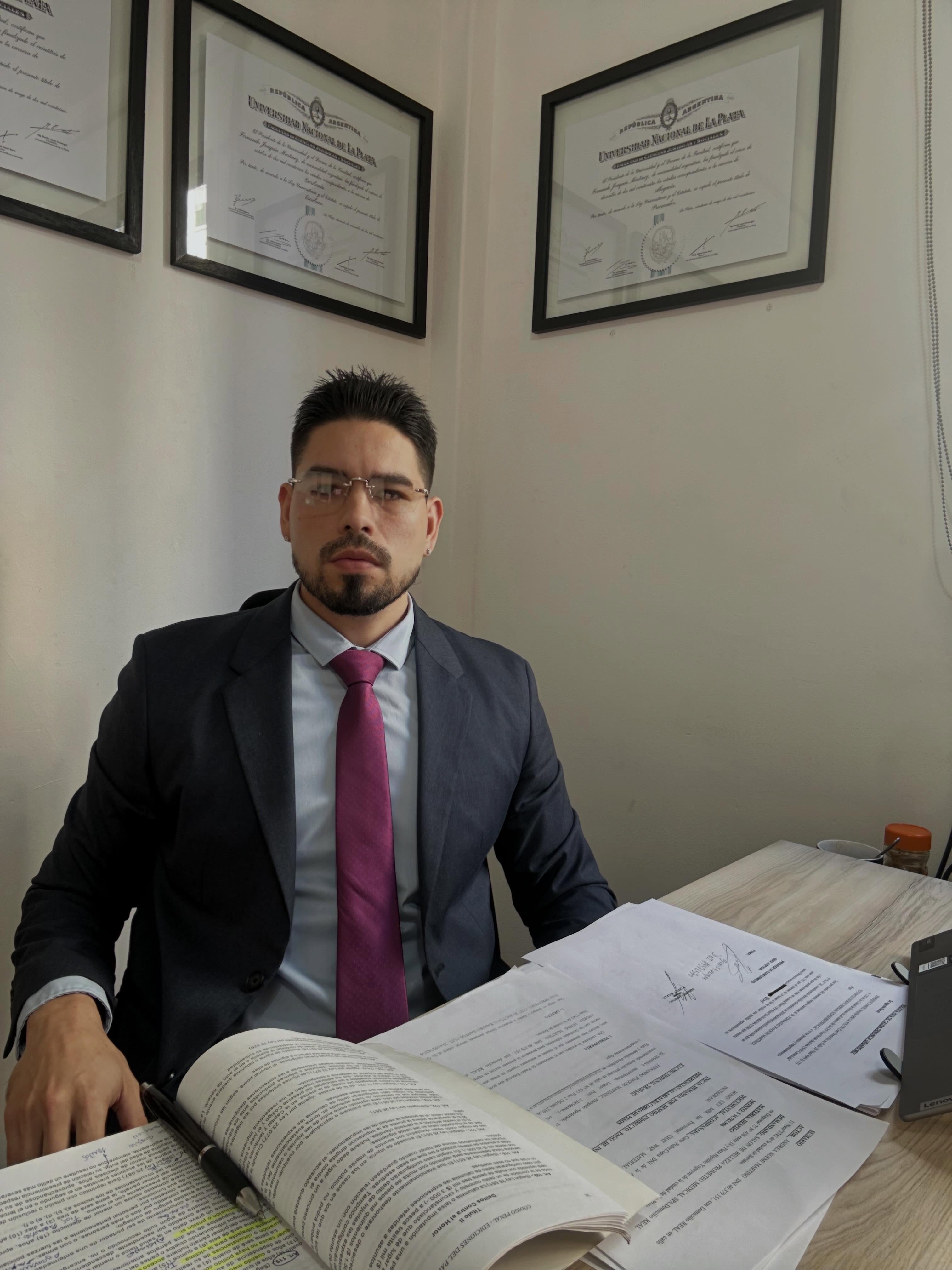 Fernando J. Martínez en su escritorio, con los diplomas de la Universidad Nacional de La Plata de fondo